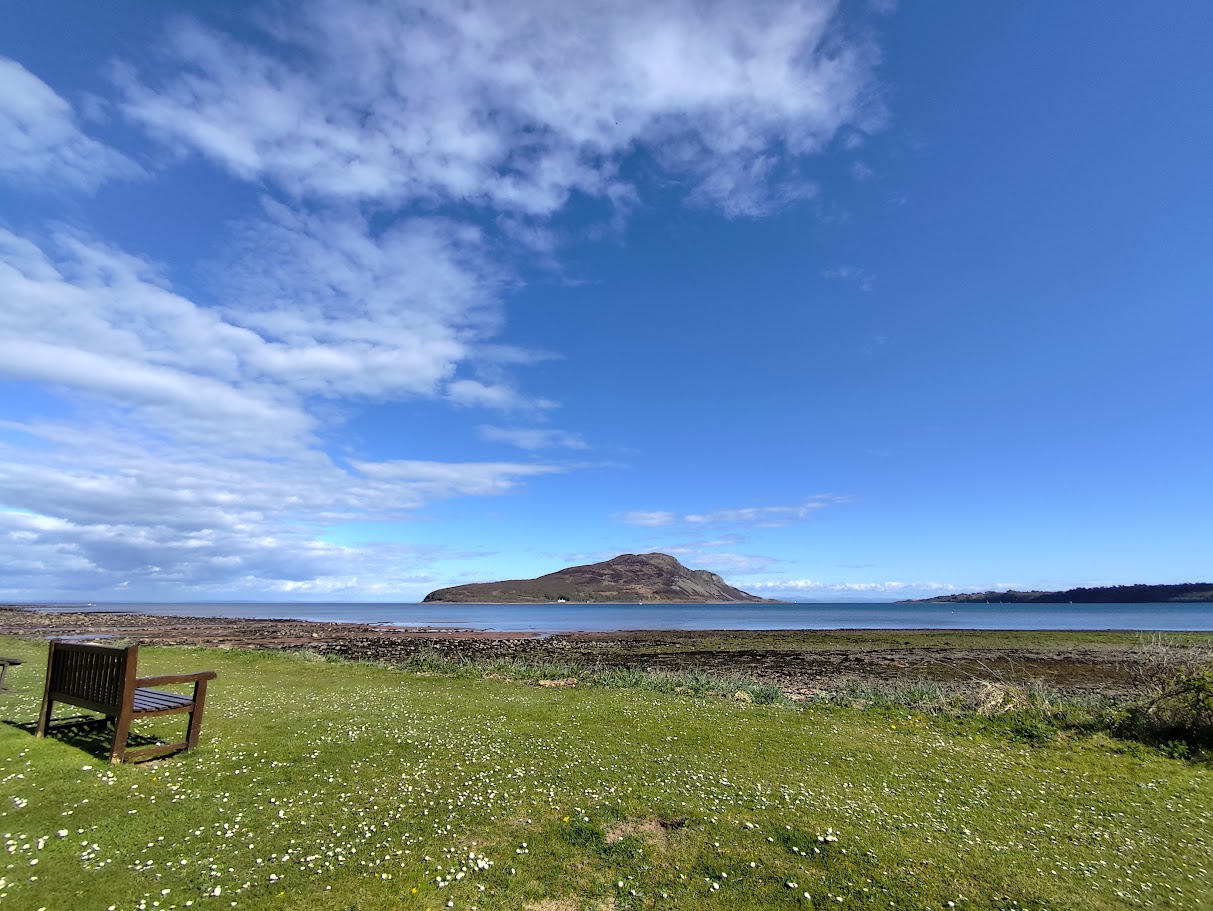 A coastal view on the Isle of Arran with hills in the distance.